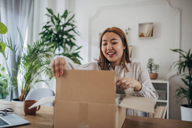 istock Young woman opening a package 1486065864