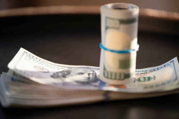 istock Hundred of US dollars on black background 1486069811