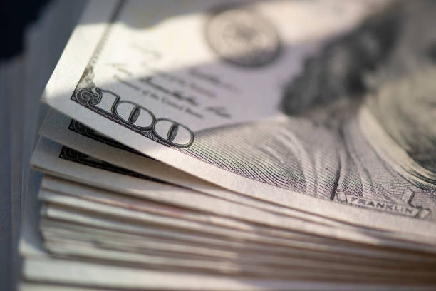 istock Hundred of US dollars on black background 1486070521
