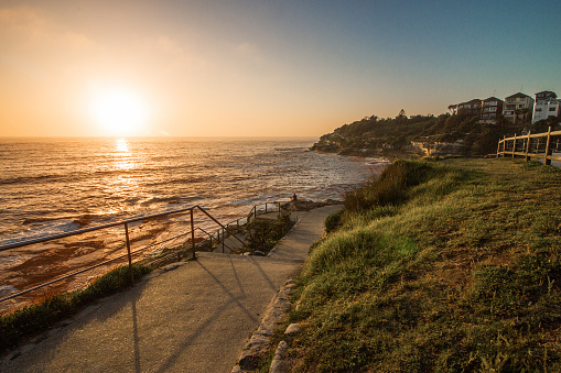 The view of the footpath in Bondi to Bronte Coastal Walk in the golden hour of the sunrise