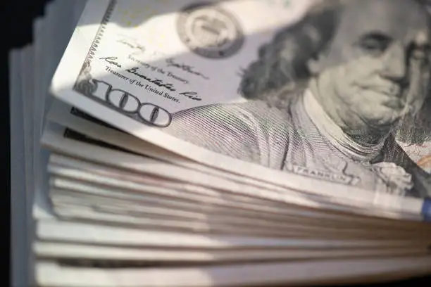 Photo of Hundred of US dollars on black background