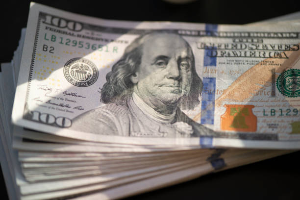 istock Hundred of US dollars on black background 1486071303