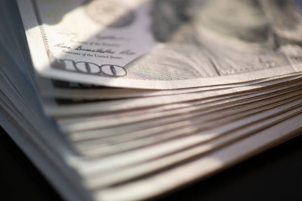 istock Hundred of US dollars on black background 1486071595