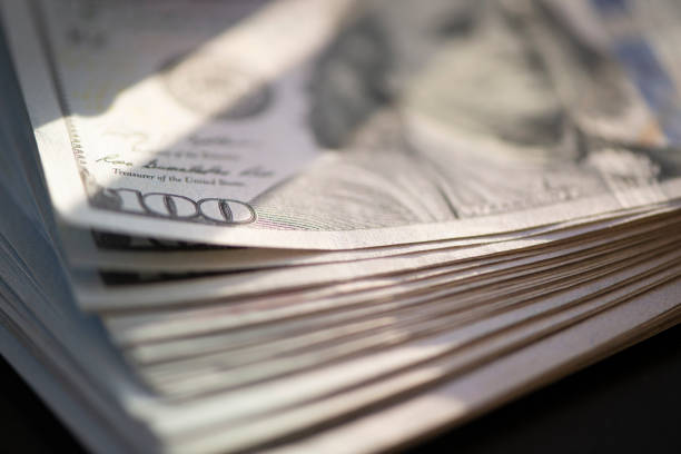 istock Hundred of US dollars on black background 1486072466