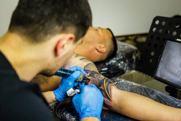 istock Artist making tattoo on man's arm 1486075159