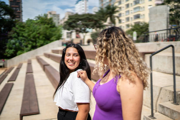 istock Happy female friends talking while walking outdoors 1486076089