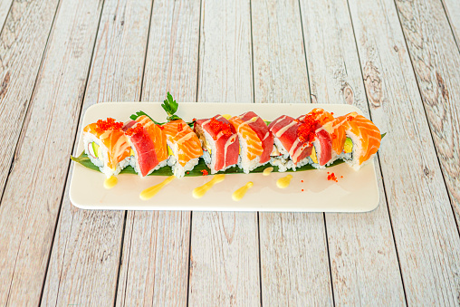 uramaki sushi roll mixed with red tuna and Norwegian salmon, recipe avocados, surimi, masago roe and nori seaweed
