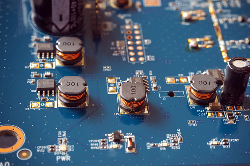 Electronic components on a motherboard. Coils, resistors and chips on the Printed Circuit Board.