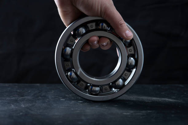 A large bearing in a hand on a dark background