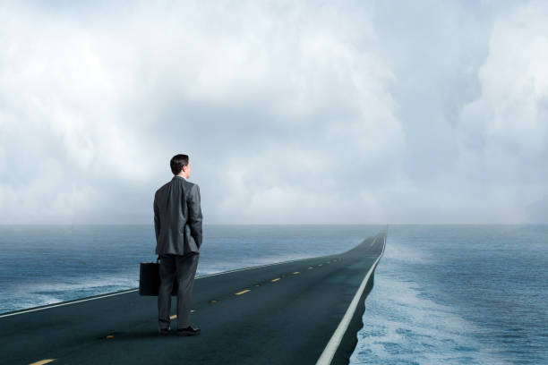 istock Man Standing On Long Dangerous Road Surrounded By Water 1486084766