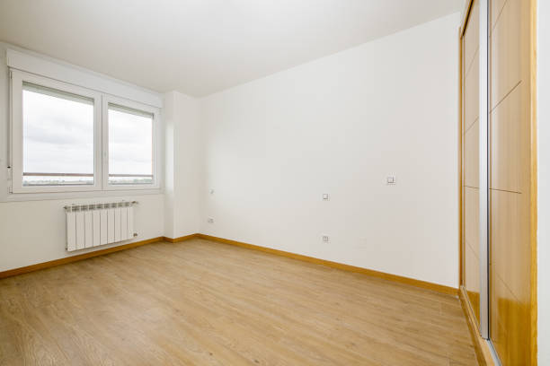 chambre avec une armoire intégrée à quatre sections avec portes en bois de chêne et sols en grès brun brillant et accumulateur de chaleur électrique - nobody brown matrial shoe cupboard photos et images de collection