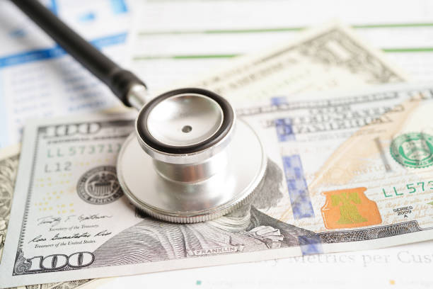 istock Stethoscope and US dollar banknotes on chart or graph paper, Financial, account, statistics and business data  medical health concept. 1486091883