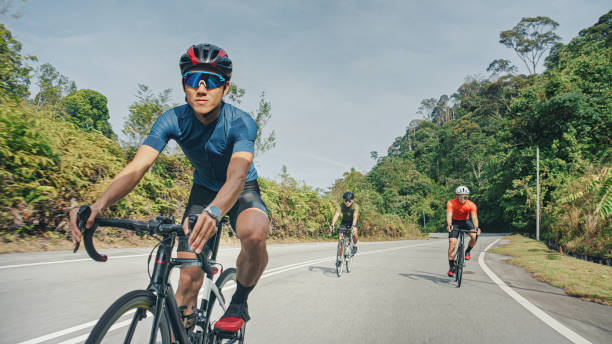 Asian Chinese male cyclist cruising downhill enjoying weekend cycling at rural scene stock photo