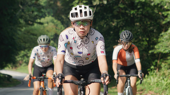 Cycling competition Asian Chinese female cyclist front view in rural scene morning