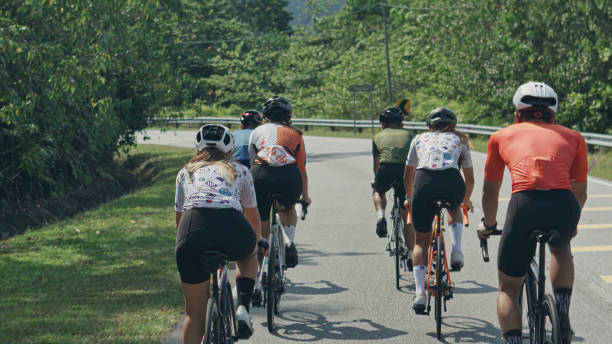Rear view Asian Chinese Cyclist leader leading team cycling in rural area during weekend morning Rear view Asian Chinese Cyclist leader leading team cycling in rural area during weekend morning cycling shorts stock pictures, royalty-free photos & images