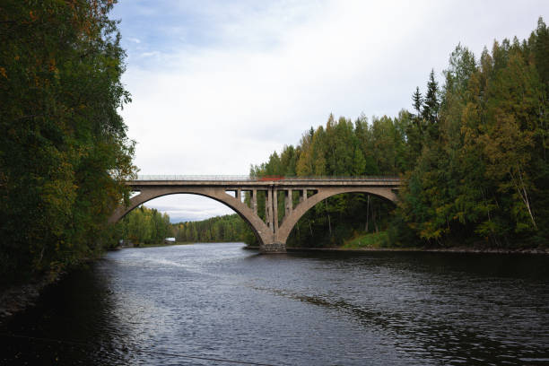istock arched bridge over a wide river surrounded by autumn forest 1486101786