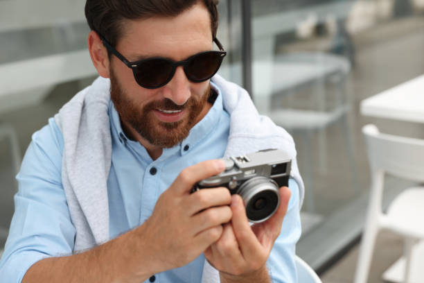 istock Man with camera in outdoor cafe. Interesting hobby 1486102182