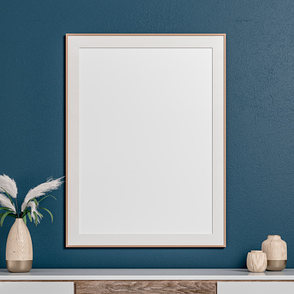 Simple interior with a white and hardwood cabinet under a large rectangle picture frame with passe-par-tout on a dark blue plaster wall background and copy space. A low rattan vase with dried plants (rushes) next to the picture frame. The 50s- 60s decoration, art Deco style. A slight vintage effect was added. 3D rendered image.