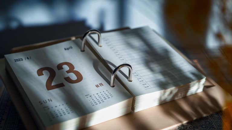 Close-up time-lapse view of a calendar notebook with flipping pages