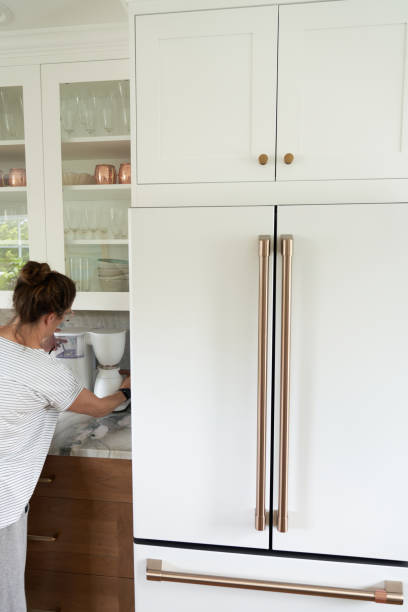 istock Rose gold and white appliances with women making coffee. 1486113094