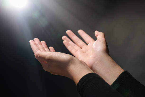 istock Woman stretching hands towards light in darkness, closeup 1486113595