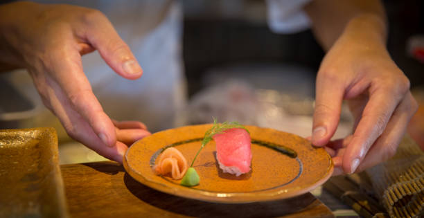 istock Japanese chef serving sushi 1486115704