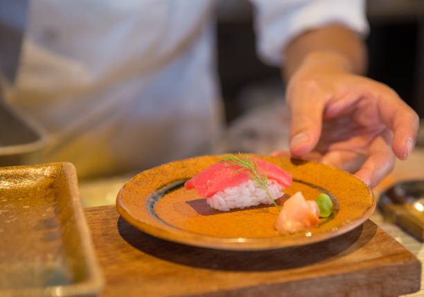 istock Japanese chef serving sushi 1486115710