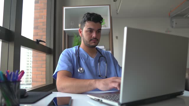Nurse man typing on laptop