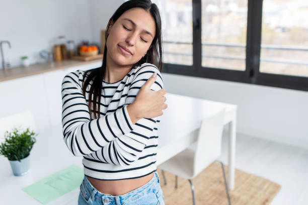 istock Paceful young woman hugging herself while relaxing in the kitchen at home 1486119506