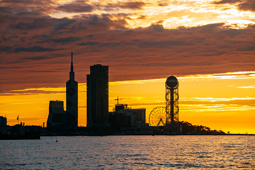 Batumi urban skyline at sunset. Shilouette of modern buildings on sunset background.