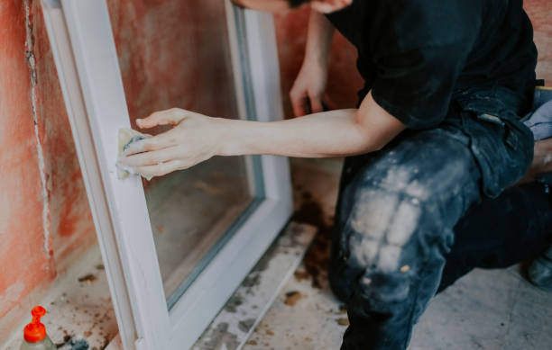 istock Caucasian male is washing window frame with sponge. 1486120713