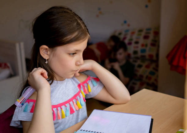 istock Beautiful schoolgirl doing homework 1486127186