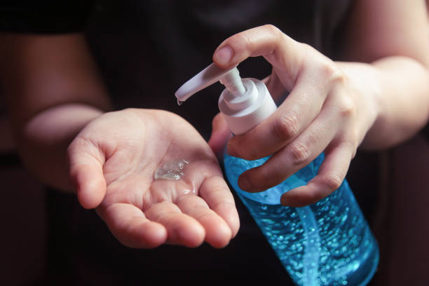 Woman using alcohol gel for cleaning hands stock photo