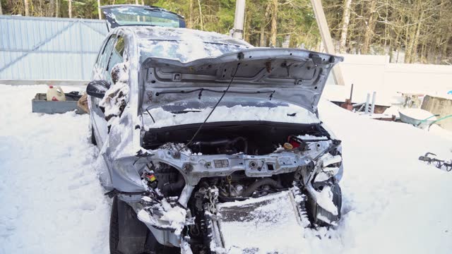 Road traffic accident with a car, car crash in the snow, a winter accident on the road, a destroyed vehicle. Frontal collision of a car