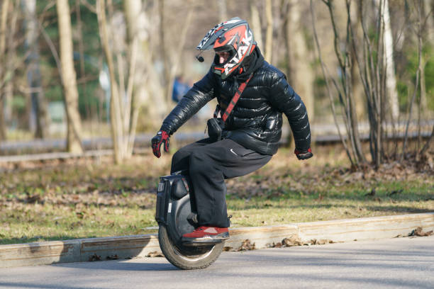 man driving electric unicycle on the spring street of moscow - unicycle men young adult standing imagens e fotografias de stock