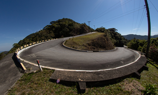 winding road with sharp turn in sunny day