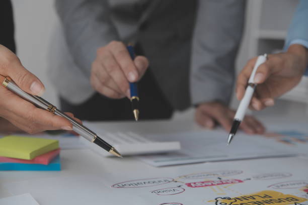 istock Financial analysts analyze business financial reports on a digital tablet planning investment project during a discussion at a meeting of corporate showing the results of their successful teamwork. 1486134452