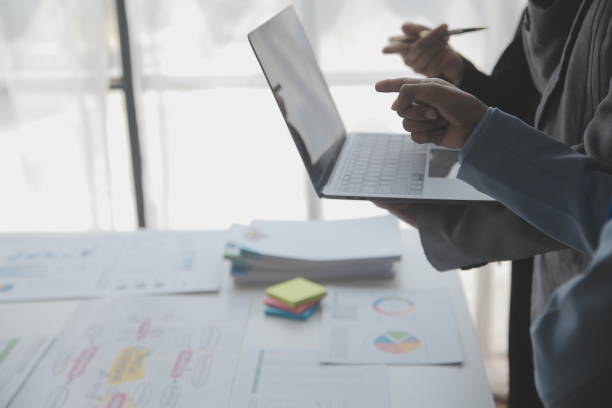 istock Financial analysts analyze business financial reports on a digital tablet planning investment project during a discussion at a meeting of corporate showing the results of their successful teamwork. 1486134521