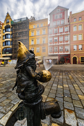 Wroclaw, Poland - July 2022: Small dwarf-refresher at market square which is a symbol of city and is squirting water on summer
