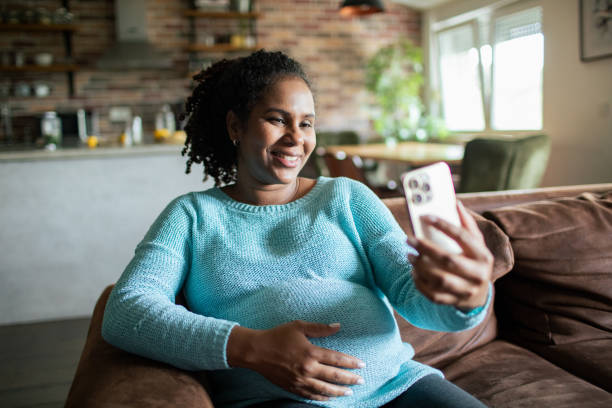 istock Young pregnant woman using a smart phone at home 1486136921