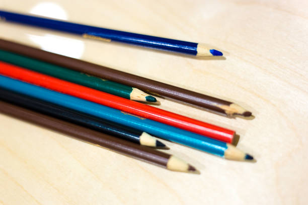 Seven Colored Pencils on Desk, Red in Middle