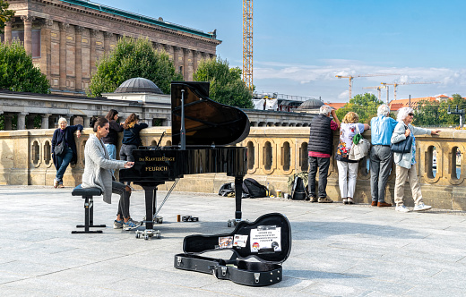 Berlin, Germany - September 25, 2022:  street musician playing the royal on the street in a historic district of Berlin