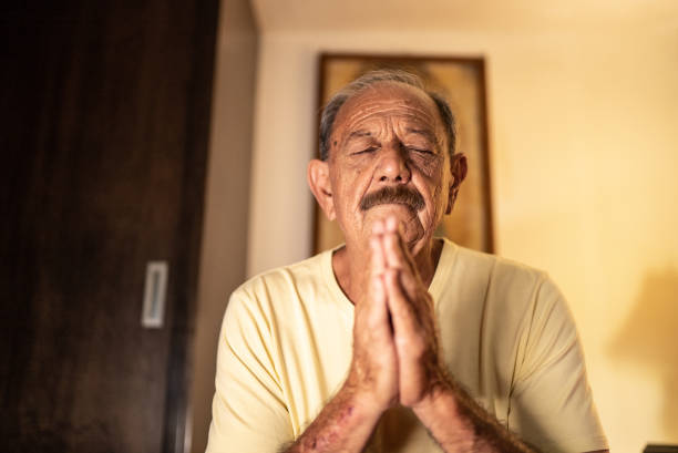 starszy mężczyzna modlący się w sypialni w domu - please god zdjęcia i obrazy z banku zdjęć