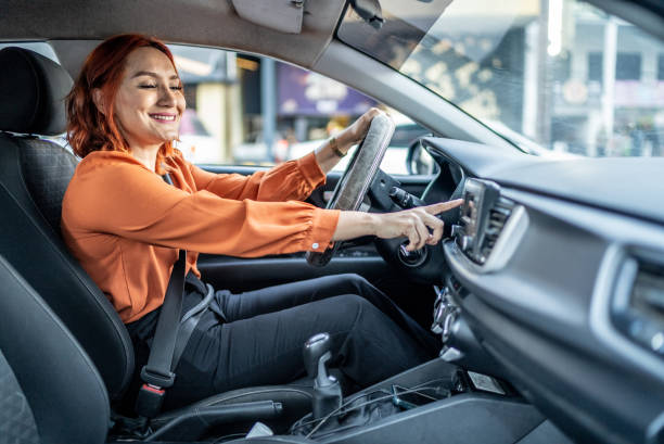 une femme adulte change de chanson en conduisant une voiture - seat belt audio photos et images de collection