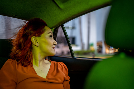 Mid adult woman looking away during an taxi drive