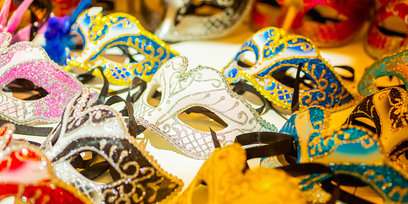 In an open-air craft fair, masks for disguise are on display for the public to see. Handmade masks typical of Venice, Italy. Souvenir stall in Venice, Italy.
