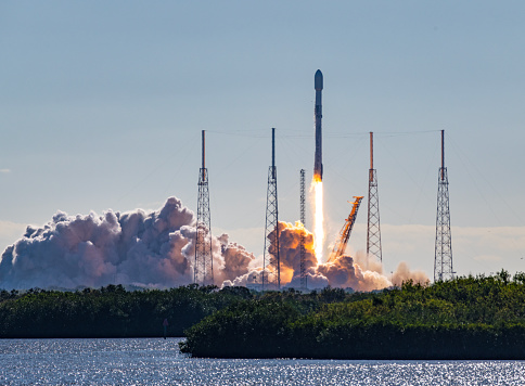 SpaceX Falcon 9 rocket and satellite payload launch in Florida. Booster are re-usable and either land at Cape Canaveral or on a barge at sea. Towers surrounding the launch pad are lightning arrestors. 
Merritt Island National Wildlife Refuge, Florida, USA
01/03/2023