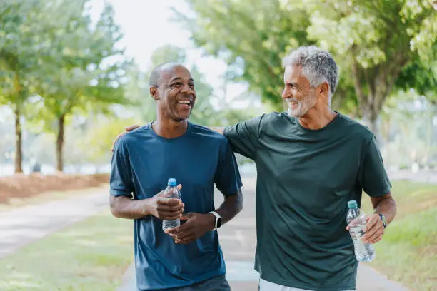 Photo of Senior friends walking in public park