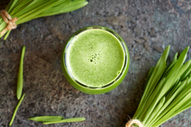 新鮮な大麦草と大麦草ジュースのグラス - wheatgrass alternative medicine detoxification juice ストックフォトと画像