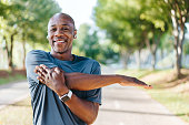 Portrait of a mature man doing stretching in public park